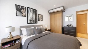 Una camera da letto moderna con un letto grande, comodini, un armadio e opere d'arte incorniciate al muro.