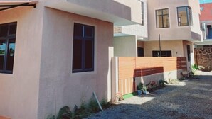 Un moderno edificio residencial de dos pisos con techo plano, ventanas amplias y entrada de grava.