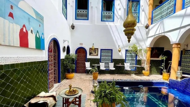 Ein Innenhof mit Schwimmbad, Fliesenboden und Topfpflanzen.