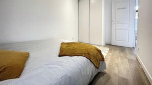 Une chambre moderne avec un lit, une armoire et une porte portant l’inscription « Chambre ».