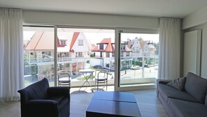 A balcony with a sofa, a table, and chairs. - Apartment in Knokke Near Driehoeksplein (Knokke-Heist)