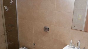 Un baño con bidé, inodoro y lavamanos.