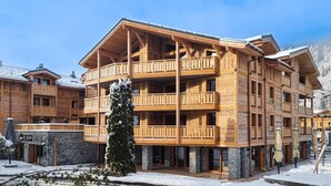 A multi-story wooden building with balconies, a stone base, and a sign reading "ICEBURG".
