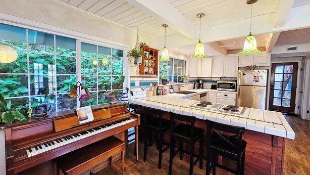 Una cocina amplia con piano, ventanas grandes y una isla central.
