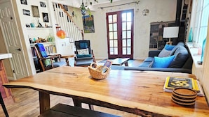Una sala de estar acogedora con una mesa de madera, un sofá y una escalera.