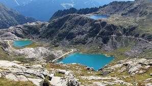 A mountainous landscape with two turquoise lakes and a winding road.