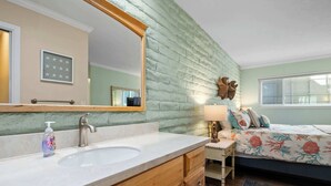 A bathroom with a sink, mirror, and wooden cabinets.