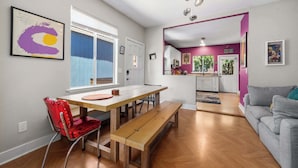 A modern apartment with a dining area, kitchen, and living space.