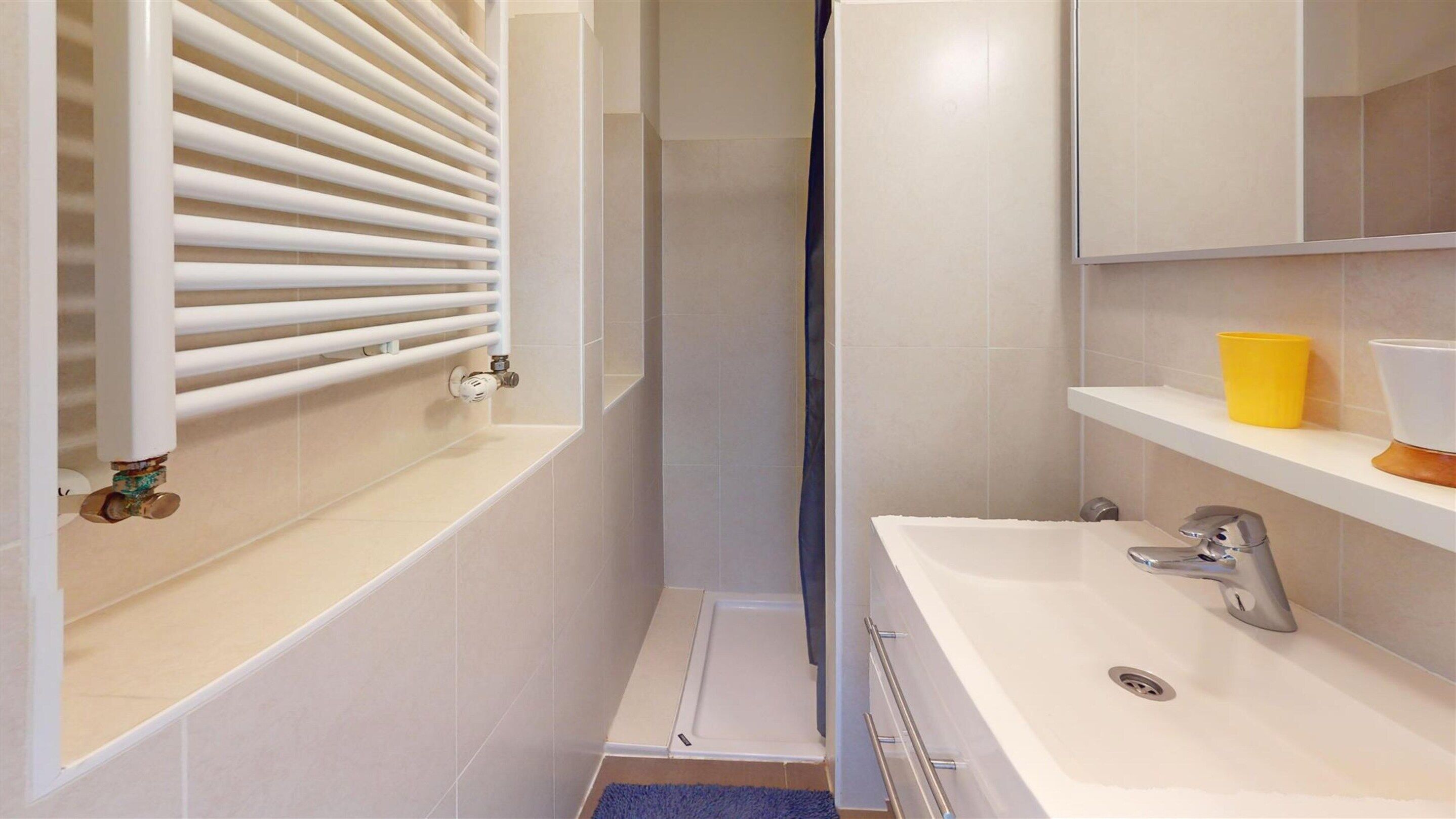 Un bagno moderno con una vasca da bagno bianca, un lavabo con uno specchio sopra e un angolo doccia.