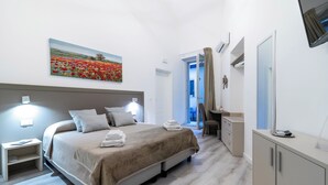 Ein modernes Hotelzimmer mit einem großen Bett, Nachttischlampen, einem Schreibtisch und einem Spiegel.