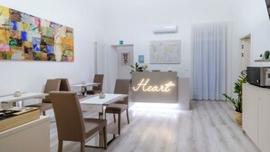 Ein zeitgemäßer Essbereich mit einem Neon-Schild mit der Aufschrift "Heart", einem großen abstrakten Gemälde und einer Weltkarte an der Wand.