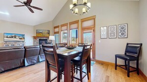 A dining area with a wooden table, chairs, and a fireplace. - Modern Mountain Retreat/Incredible Mountain Views/Stylish Kitchen/Spotless (Estes Park)