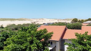 A coastal property with a red-tiled roof, surrounded by greenery and a sandy beach in the background. - Hossegor Les Semis in front of the Gravière dune (Soorts-Hossegor)