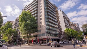 Ein mehrstöckiges Gebäude mit modernem Design, mit Balkonen und großen Fenstern.