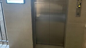 Ein metallener Aufzug mit Bedienfeld auf der rechten Seite.