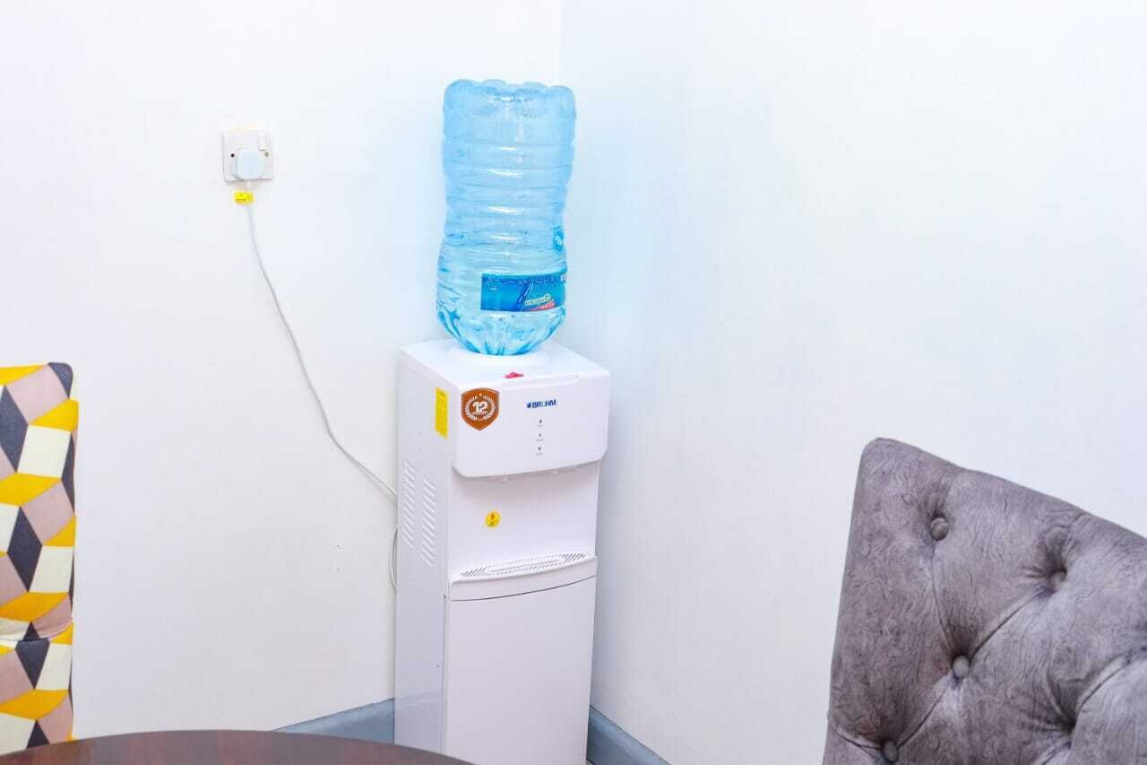 Un distributeur d’eau muni d’une grande bouteille d’eau placée sur le dessus et branché à une prise murale.