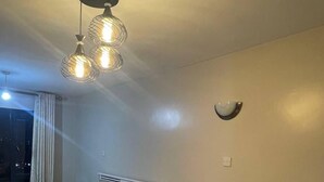 Ein Hotelzimmer mit Bett, Sofa, rundem Tisch und einer Deckenleuchte.