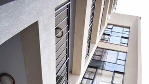 Ein mehrstöckiges Gebäude mit modernem architektonischen Design, das große Fenster und Balkone aufweist.