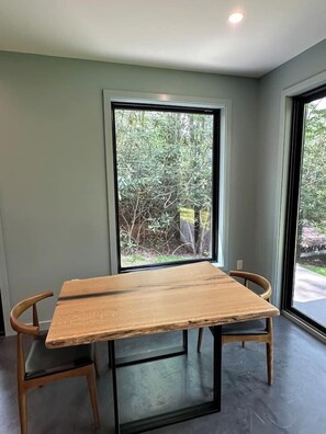 A room with a large window, a wooden table, and two chairs. - Secluded Mountain Escape | River • Hot Tub • Waterfalls • Mountain Views (Marion)