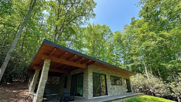 A modern outdoor structure with a stone facade, wooden beams, and a covered patio area. - Secluded Mountain Escape | River • Hot Tub • Waterfalls • Mountain Views (Marion)