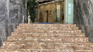 A marble staircase leading to a lobby with a modern design, including a plant and a blue carpet. - Ocean Vista Marina Suites Nha Trang (Nha Trang)
