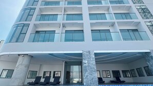 A tall, modern building with a pool in the foreground. - Ocean Vista Marina Suites Nha Trang (Nha Trang)
