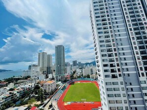 A high-rise building with a view of a stadium and surrounding cityscape.