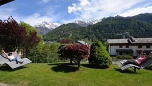 A scenic outdoor area with two reclining chairs facing a mountainous backdrop. - Hotel Sorriso  (Temu)