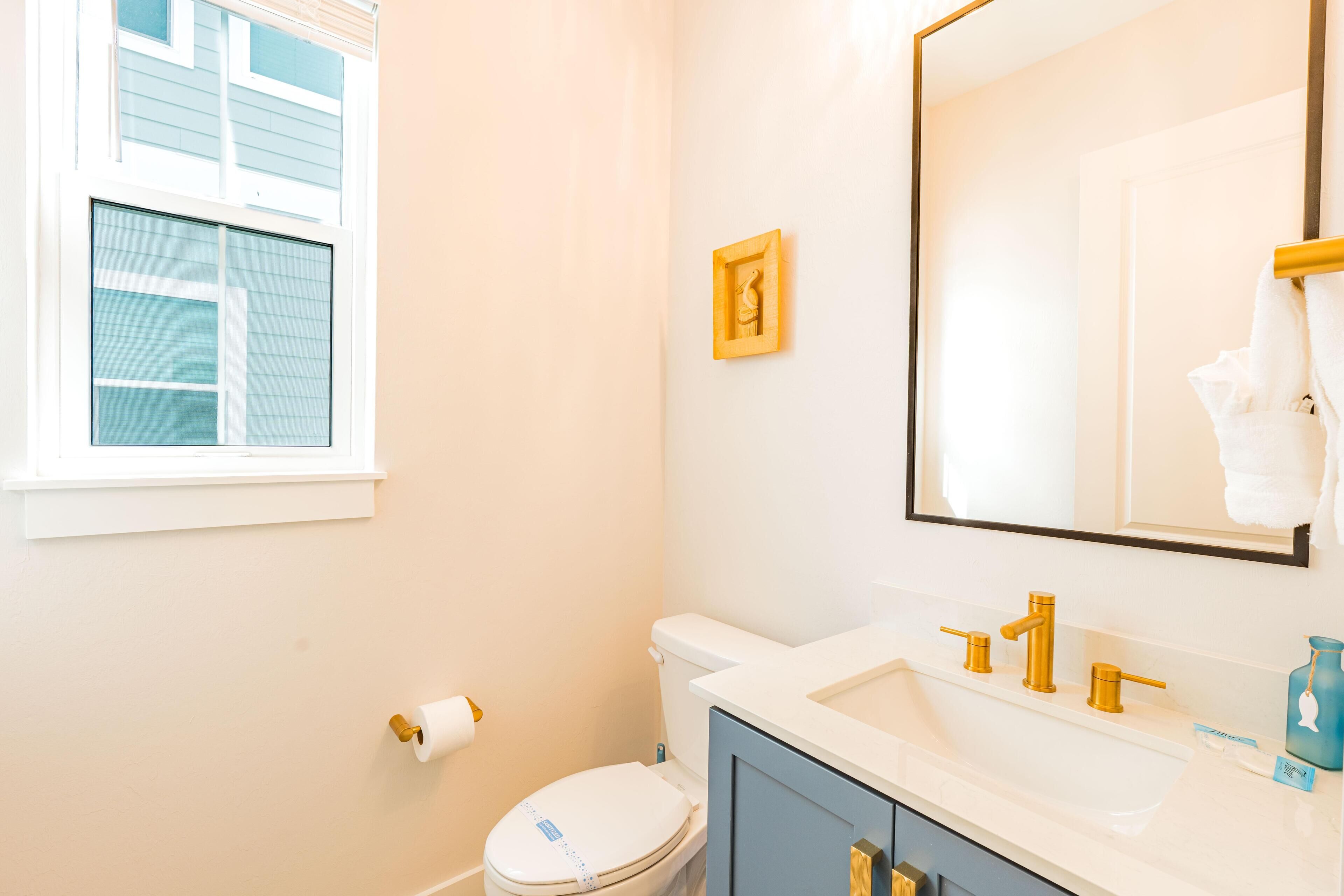A bathroom with a toilet, sink, and mirror.