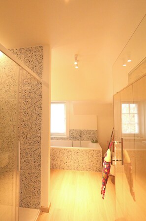 A modern bathroom with a shower, a toilet, and a sink. There is a window providing natural light. - Villa in Het Zoute Near Zeedijk Promenade (Knokke-Heist)