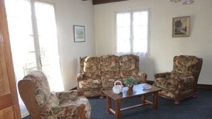 A living room with patterned armchairs, a sofa, and a coffee table. - Purple perigord house (Lanquais)