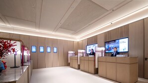 A reception area with a modern design, featuring a reception desk, a large digital screen, and a clean, minimalist decor.