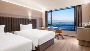 A hotel room with two beds, a desk, a chair, and a large window offering a city view. - Intercity Hotel Shanghai Hongqiao Airport (Shanghai)