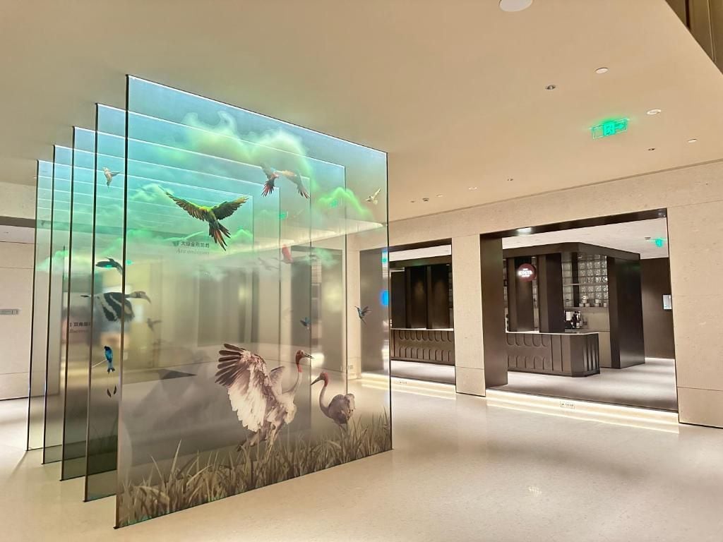 A modern interior with a glass display of birds in flight, a reception area, and a clean, minimalist design.