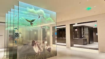 A modern interior with a glass display of birds in flight, a reception area, and a clean, minimalist design.
