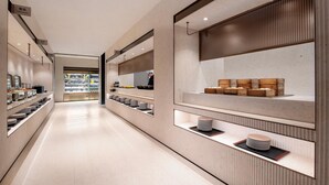 A modern, well-lit corridor with display shelves on both sides, leading to a counter area. - Intercity Hotel Shanghai Hongqiao Airport (Shanghai)