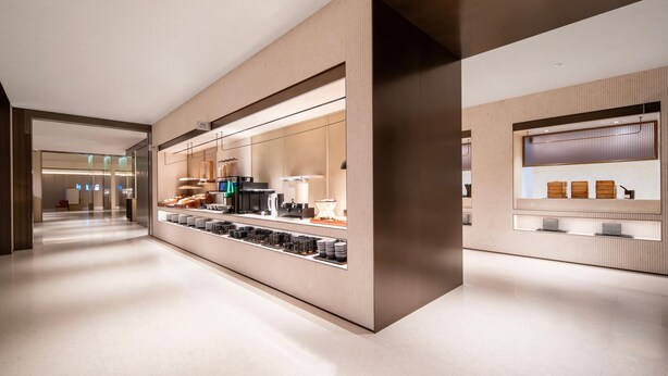 A modern hotel lobby with a long reception desk, glass partitions, and a clean, minimalist design.