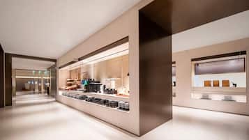 A modern hotel lobby with a long reception desk, glass partitions, and a clean, minimalist design.