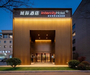 Das Intercity Hotel mit moderner Fassade, großem Eingang und einer Beschilderung in Englisch und Chinesisch.