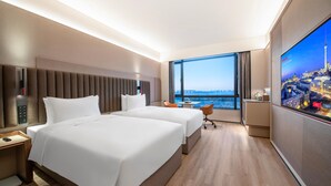 A hotel room with two beds, a desk, a chair, a TV, and a large window offering a city view. - Intercity Hotel Shanghai Hongqiao Airport (Shanghai)