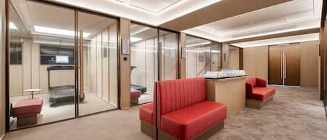 A modern hotel lobby with a red sofa, a small table, and a glass partition wall.