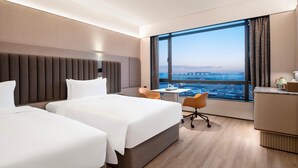 A hotel room with two beds, a desk, a chair, and a large window with a city view. - Intercity Hotel Shanghai Hongqiao Airport (Shanghai)