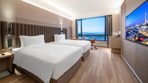A hotel room with two beds, a large window with a city view, a flat-screen TV, and a small table. - Intercity Hotel Shanghai Hongqiao Airport (Shanghai)