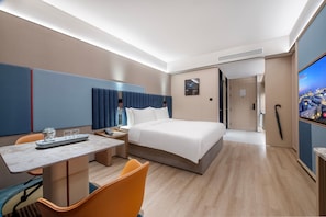 A modern hotel room with a large bed, a desk with a chair, a television, and a cityscape view. - Intercity Hotel Shanghai Hongqiao Airport (Shanghai)