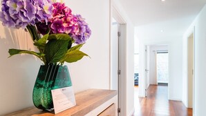 A hallway with a wooden bench and a vase of flowers on it. - GuestReady - Relaxing Funchal Retreat (Funchal)