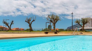 A swimming pool with clear blue water, surrounded by trees and a clear sky. - GuestReady - Relaxing Funchal Retreat (Funchal)