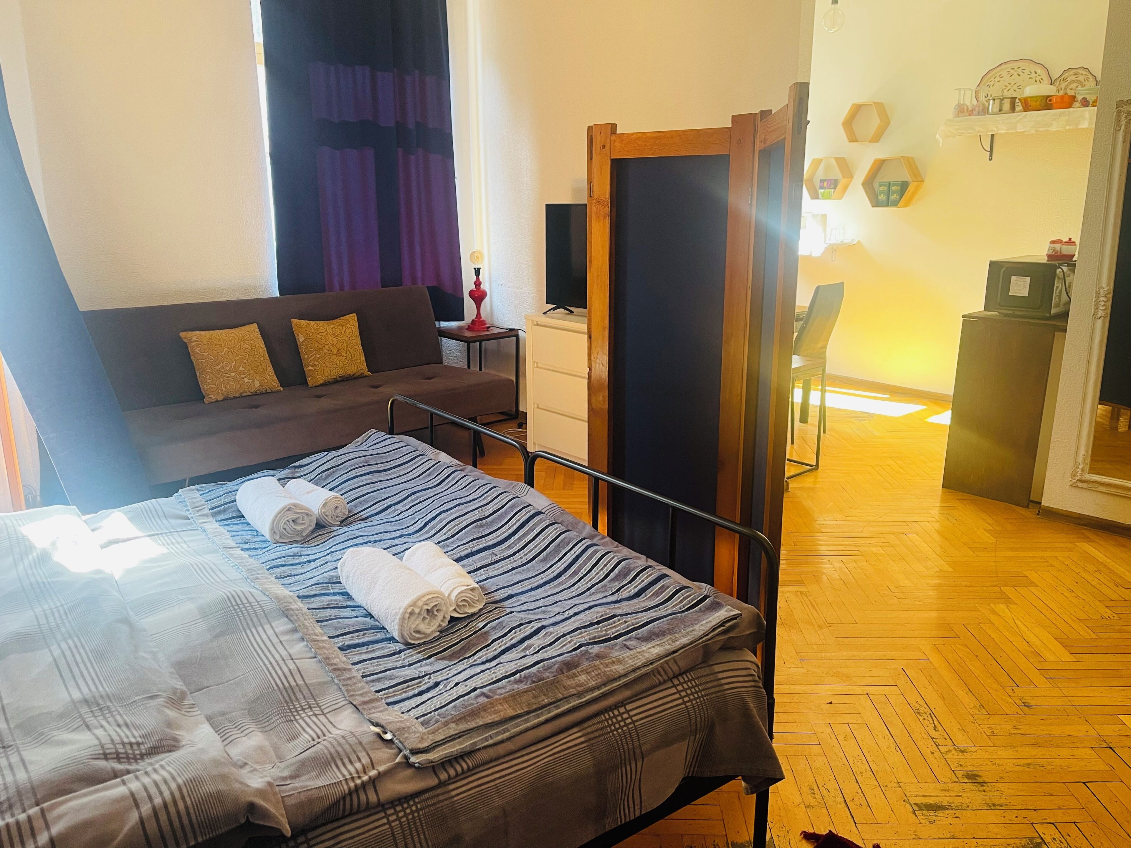 Un dormitorio con una cama, un sofá, una mesita y un armario.