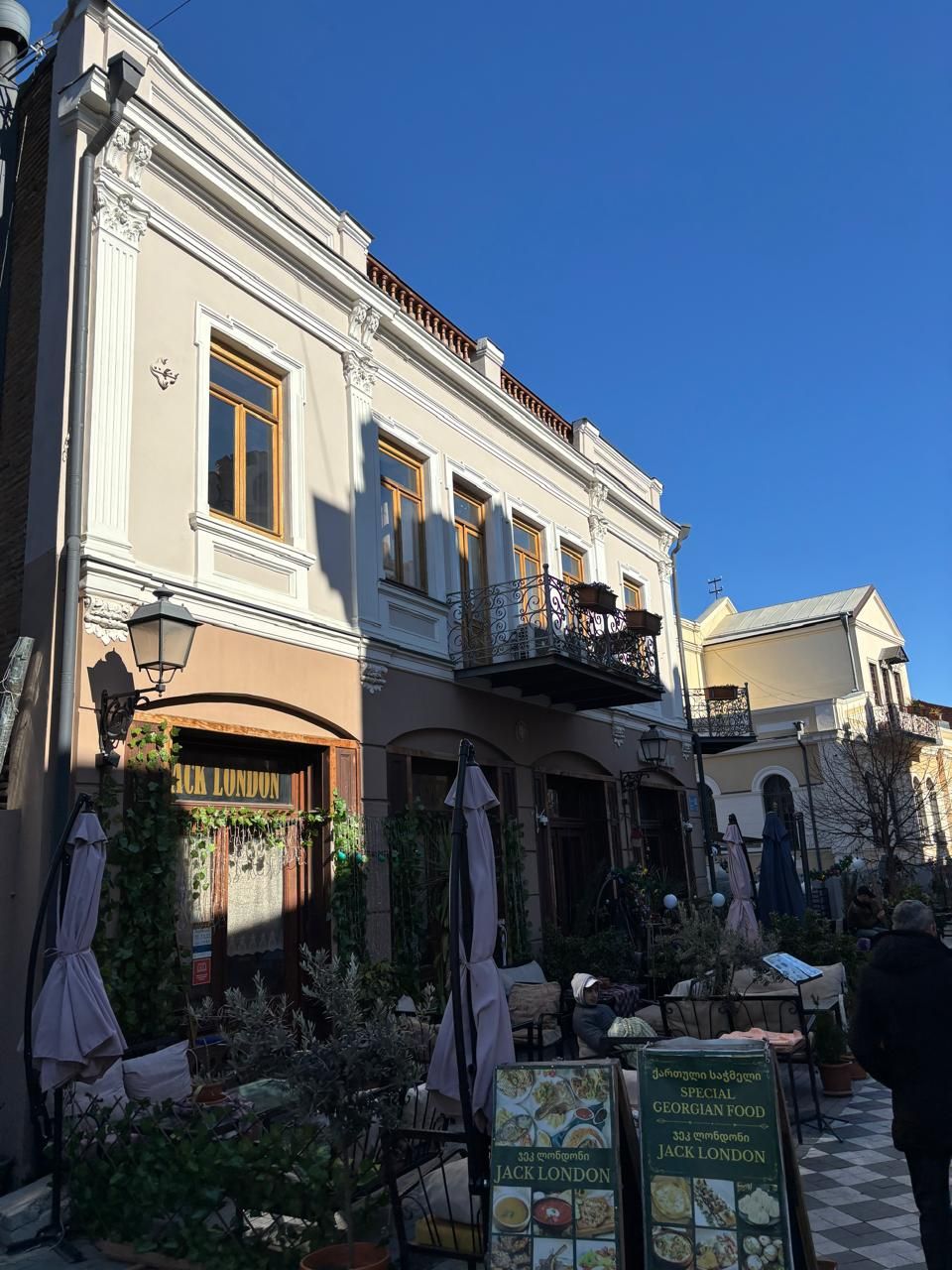 Un bâtiment sur lequel on peut lire l’inscription « JACK LONDON », et une terrasse avec des parasols.