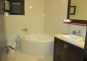 Un baño con bañera, inodoro y lavamanos.