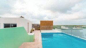 A rooftop swimming pool with a view of the cityscape. - Charming 2-bedroom condo in Tulum with WiFi, AC (Tulum)